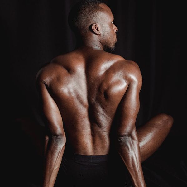 Man performing a core strength exercise in a dark room.